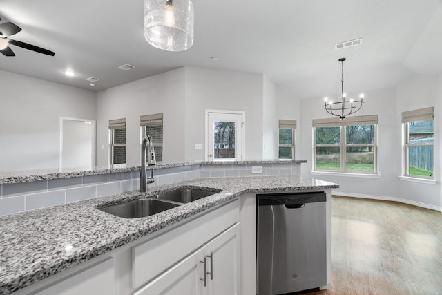 kitchen featuring sink, white cabinets, stainless steel dishwasher, light hardwood / wood-style floors, and light stone countertops