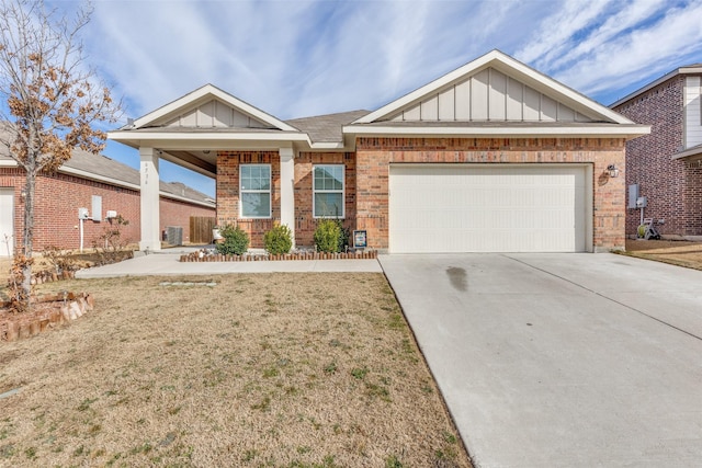 view of front of property with brick siding, board and batten siding, concrete driveway, a front yard, and a garage