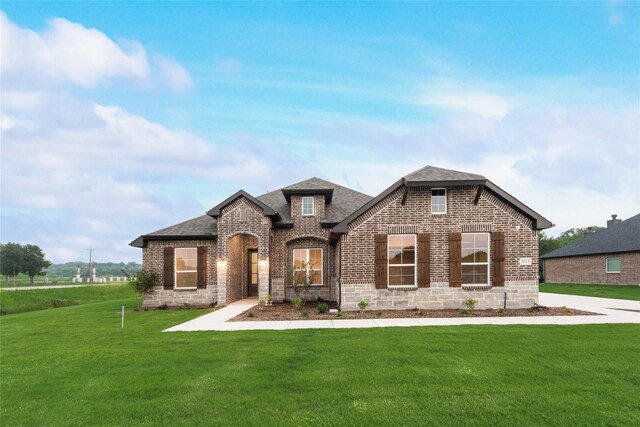 3915 Southern Oaks Dr, Royse City, TX 75189 - french country inspired facade with brick siding, roof with shingles, and a front lawn