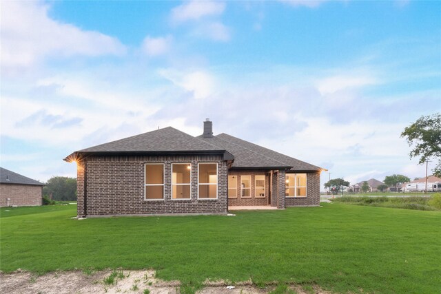 3915 Southern Oaks Dr, Royse City, TX 75189 - back of house with a shingled roof, a lawn, a chimney, and brick siding