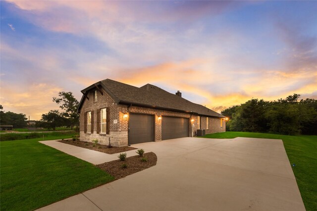 3915 Southern Oaks Dr, Royse City, TX 75189 - view of front of home featuring brick siding, an attached garage, a yard, driveway, and central AC