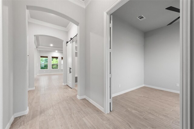 3915 Southern Oaks Dr, Royse City, TX 75189 - corridor with arched walkways, crown molding, light wood-type flooring, a barn door, and baseboards