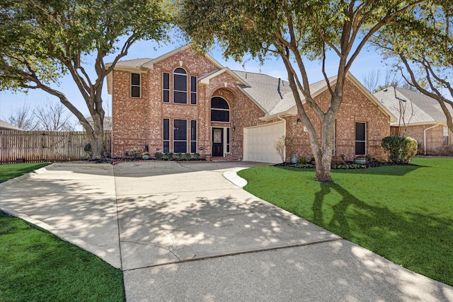 traditional-style house featuring an attached garage, brick siding, fence, driveway, and a front lawn