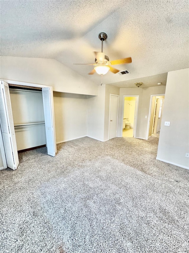 unfurnished bedroom featuring two closets, vaulted ceiling, ceiling fan, and carpet