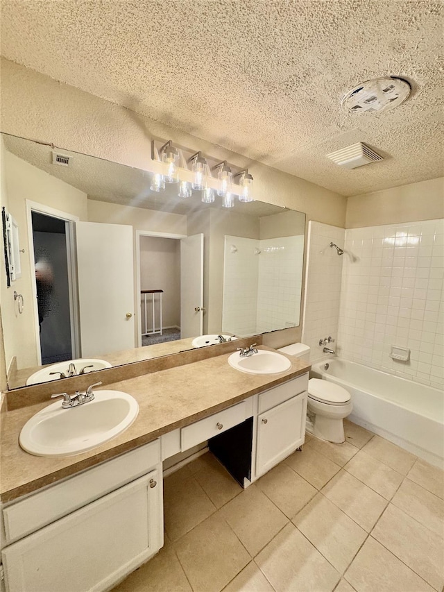 full bathroom featuring toilet, tiled shower / bath, a textured ceiling, vanity, and tile patterned flooring