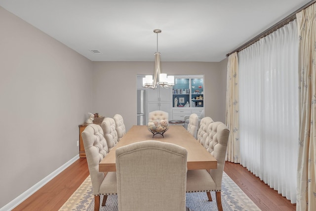 dining area featuring an inviting chandelier and light hardwood / wood-style flooring