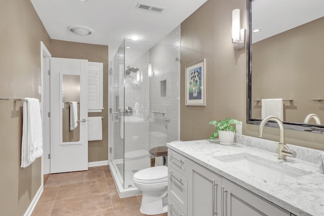 bathroom featuring vanity, toilet, a shower with shower door, and tile patterned flooring