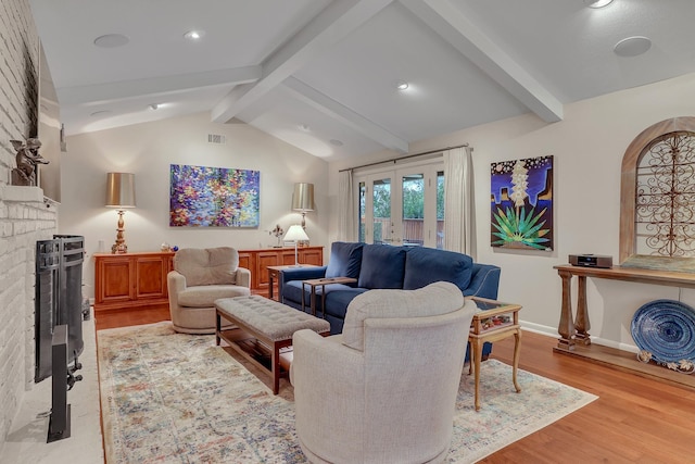 living room with lofted ceiling with beams, a brick fireplace, french doors, and light hardwood / wood-style flooring