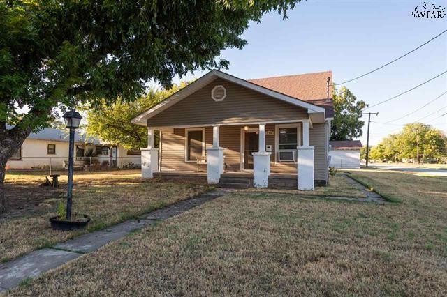 bungalow-style home featuring a front lawn and covered porch