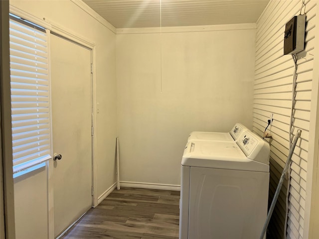 washroom with dark wood-type flooring, ornamental molding, and washer and clothes dryer