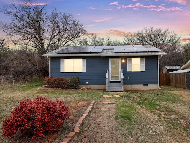 view of front of home featuring a yard and solar panels