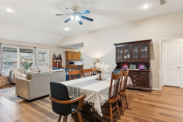 dining area featuring vaulted ceiling, ceiling fan, and light wood-type flooring