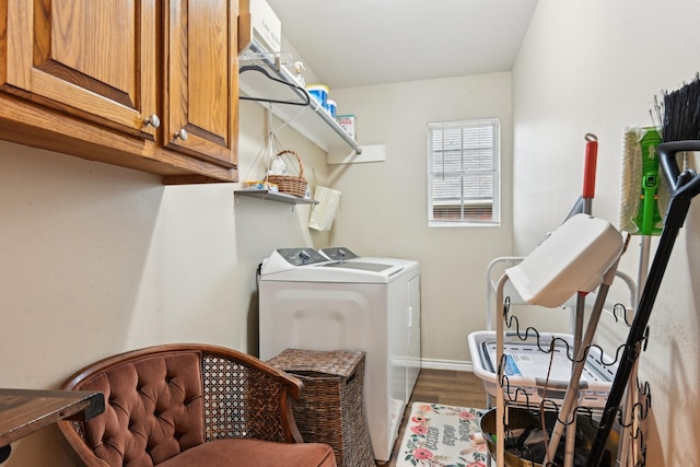 laundry area featuring cabinets, washing machine and dryer, and dark hardwood / wood-style floors