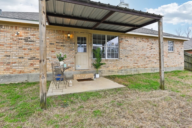 doorway to property featuring a patio and a lawn