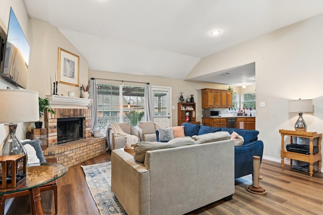 living room featuring a wealth of natural light, vaulted ceiling, and light wood-type flooring