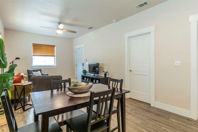 dining space with baseboards, visible vents, a ceiling fan, and light wood-style floors