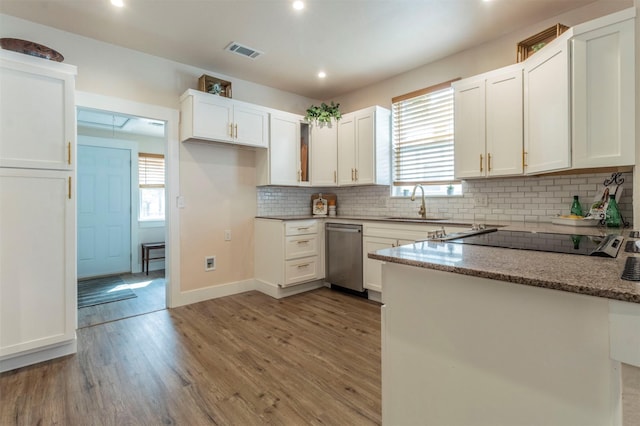 kitchen with visible vents, backsplash, light wood-style floors, white cabinetry, and a sink