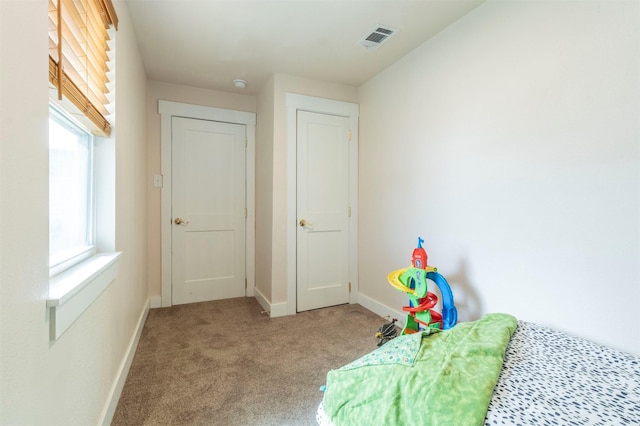 unfurnished bedroom featuring carpet flooring, baseboards, and visible vents