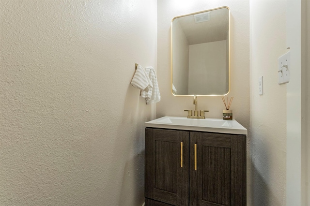 bathroom with vanity and a textured wall