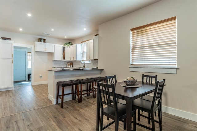 dining room featuring baseboards and light wood finished floors