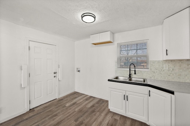 2717 Eagle Dr, Dallas, TX 75216 - kitchen with sink, a textured ceiling, hardwood / wood-style floors, decorative backsplash, and white cabinets