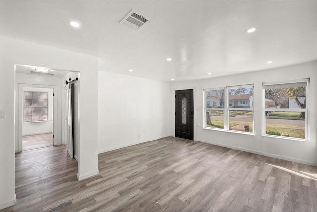 2717 Eagle Dr, Dallas, TX 75216 - unfurnished room featuring a barn door and light hardwood / wood-style floors