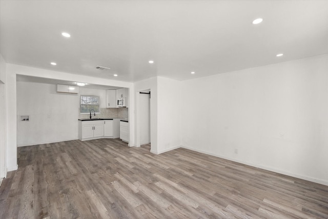 2717 Eagle Dr, Dallas, TX 75216 - unfurnished living room featuring sink and light hardwood / wood-style floors