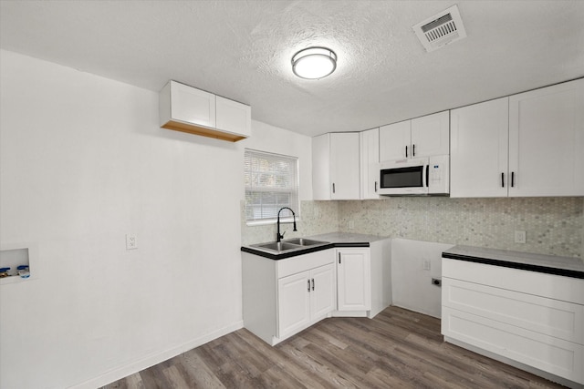 2717 Eagle Dr, Dallas, TX 75216 - kitchen featuring white cabinetry, sink, and light hardwood / wood-style flooring