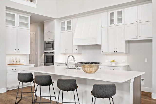 kitchen featuring a sink, custom exhaust hood, appliances with stainless steel finishes, and dark wood-style floors