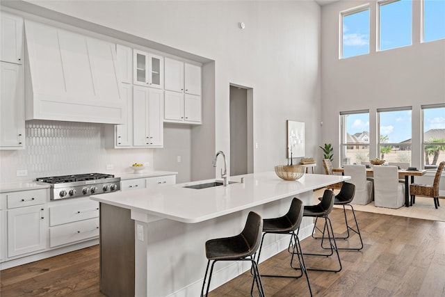 kitchen with dark wood-type flooring, stainless steel gas stovetop, and a wealth of natural light