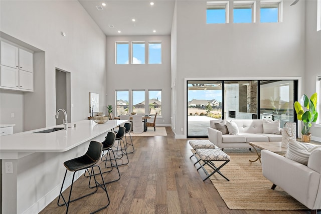 living area featuring a wealth of natural light, baseboards, wood finished floors, and recessed lighting