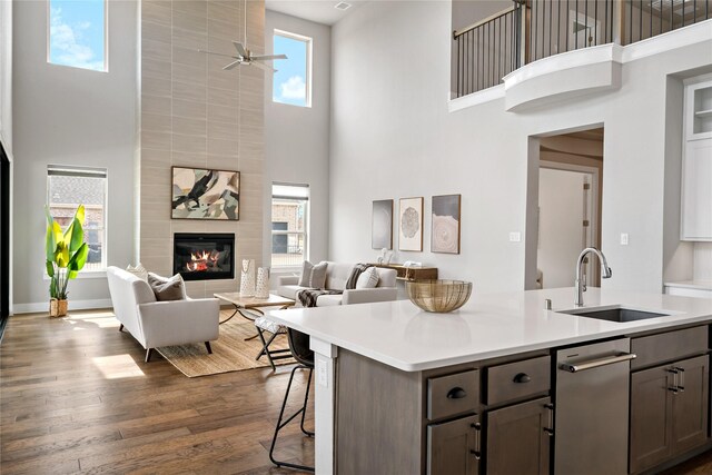 kitchen with light countertops, dark wood-style floors, plenty of natural light, a ceiling fan, and a sink