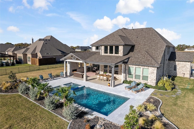 view of pool with a patio, an outdoor kitchen, an outdoor living space, a fenced backyard, and a lawn