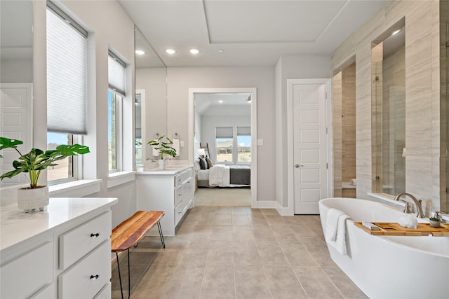 bathroom with vanity, baseboards, a freestanding tub, recessed lighting, and connected bathroom