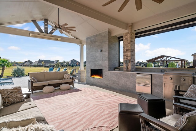 view of patio with exterior kitchen and an outdoor living space with a fireplace