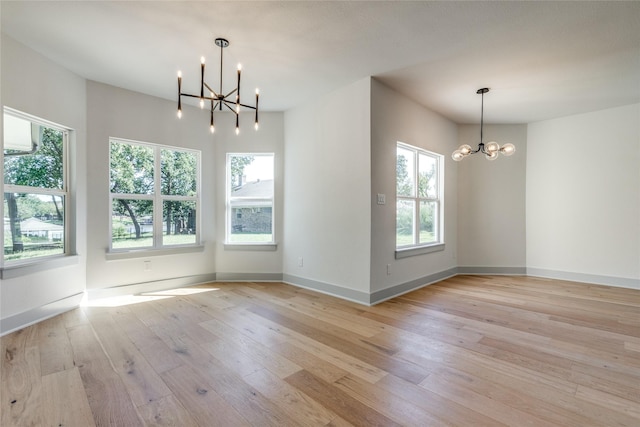 unfurnished dining area with light hardwood / wood-style flooring and a chandelier