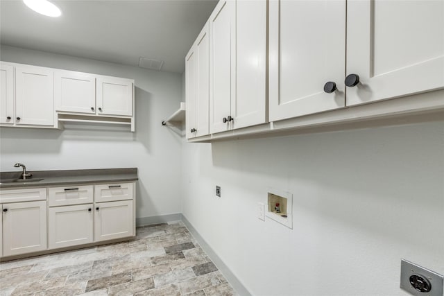 clothes washing area with electric dryer hookup, sink, hookup for a washing machine, and cabinets