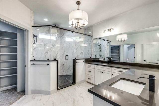 bathroom featuring vanity, a chandelier, and walk in shower