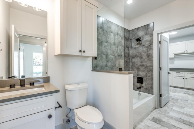 full bathroom with tiled shower / bath combo, vanity, and toilet