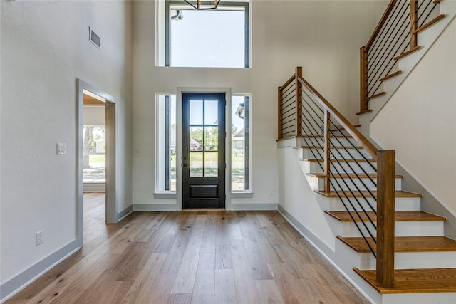 foyer entrance with a high ceiling and light wood-type flooring