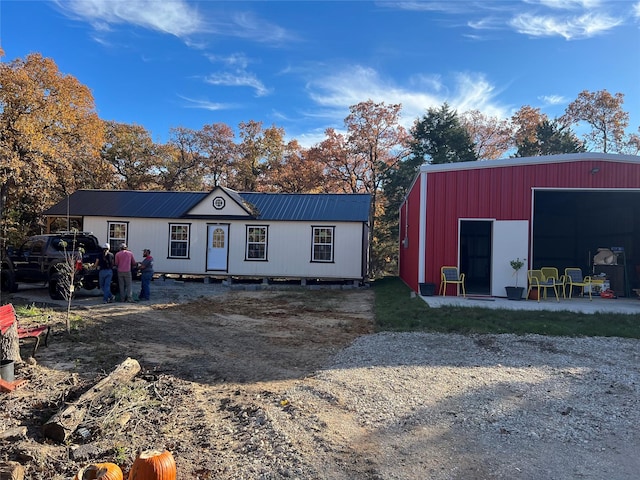 view of front of house with an outbuilding, metal roof, and an outdoor structure