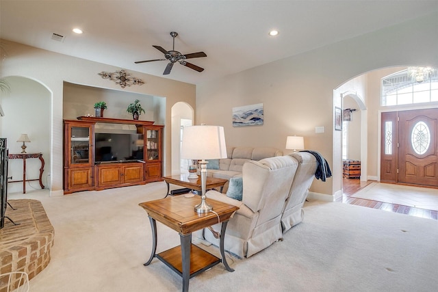 living room with ceiling fan with notable chandelier and light colored carpet