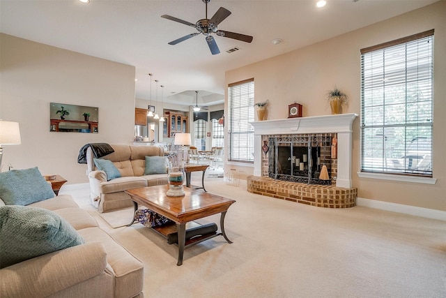 carpeted living room featuring ceiling fan, a healthy amount of sunlight, and a fireplace