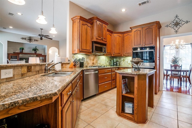 kitchen featuring sink, kitchen peninsula, ceiling fan, stainless steel appliances, and decorative backsplash