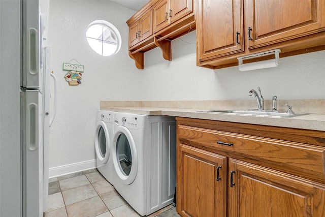 washroom with sink, light tile patterned floors, and washing machine and clothes dryer