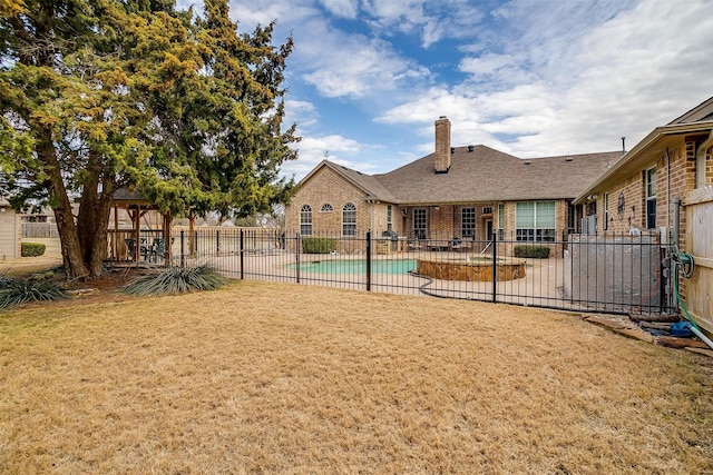 rear view of property with a fenced in pool, a yard, a patio, and a gazebo