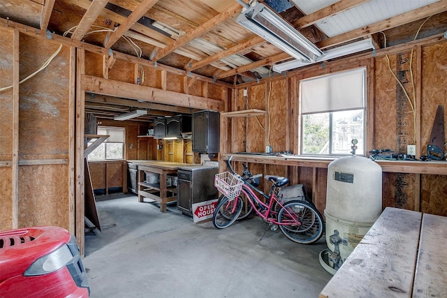 miscellaneous room with concrete flooring, a workshop area, and a healthy amount of sunlight