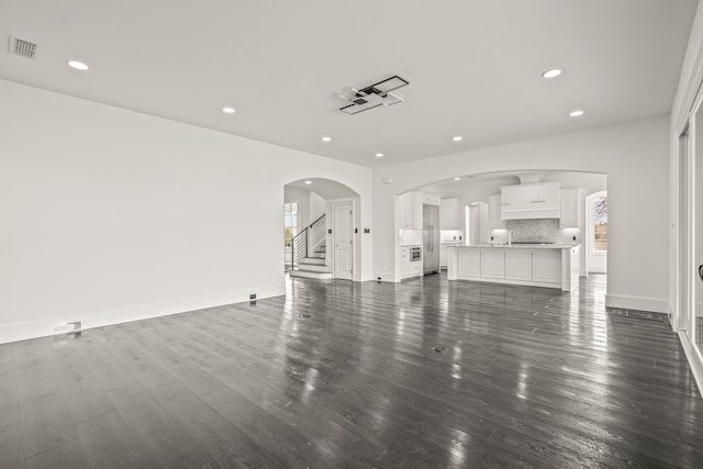 unfurnished living room with dark wood-type flooring and a wealth of natural light