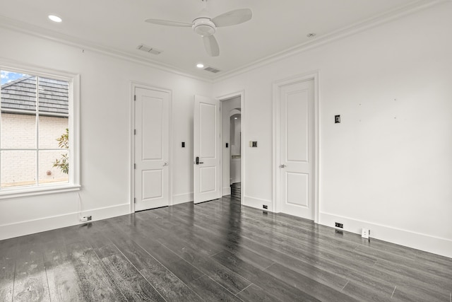 empty room featuring ornamental molding, dark wood-type flooring, and ceiling fan