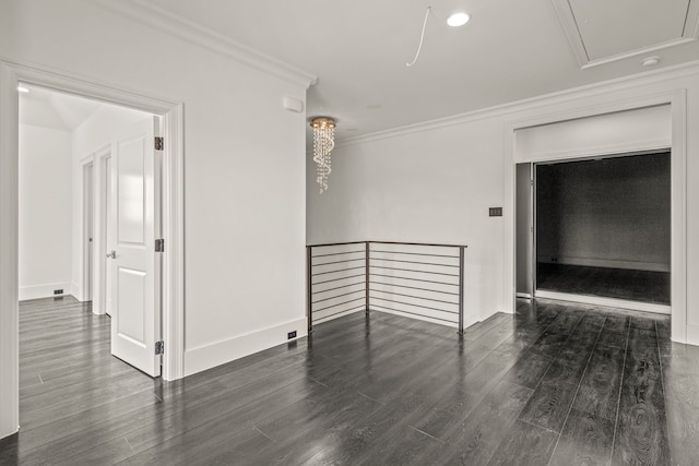 empty room featuring ornamental molding and dark wood-type flooring